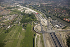 802622 Luchtfoto van de landtunnel in de autosnelweg A2 te Utrecht, uit het zuiden; op de voorgrond het verkeersplein ...